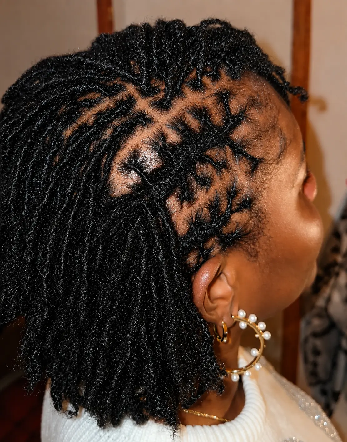 Side view of small locs with a diamond parting pattern, showing clean even sections and an intact hairline