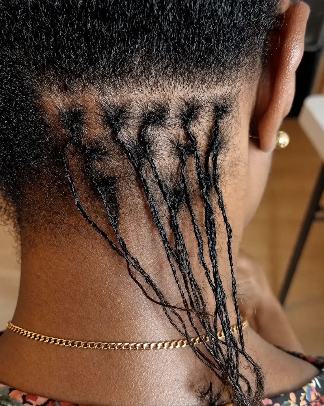 Close up of the nape on a new starter set, the first locs sectioned off in small even partings against the scalp
